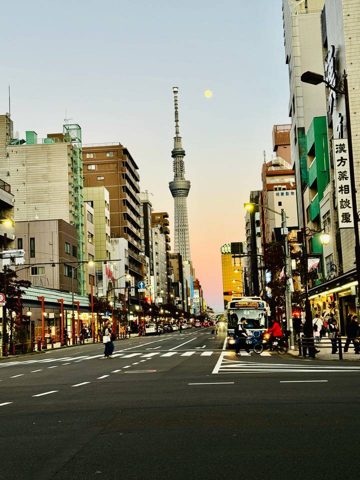 Straßenansicht von Tokio mit dem Tokyo Skytree, eingerahmt von Gebäuden bei Sonnenuntergang.