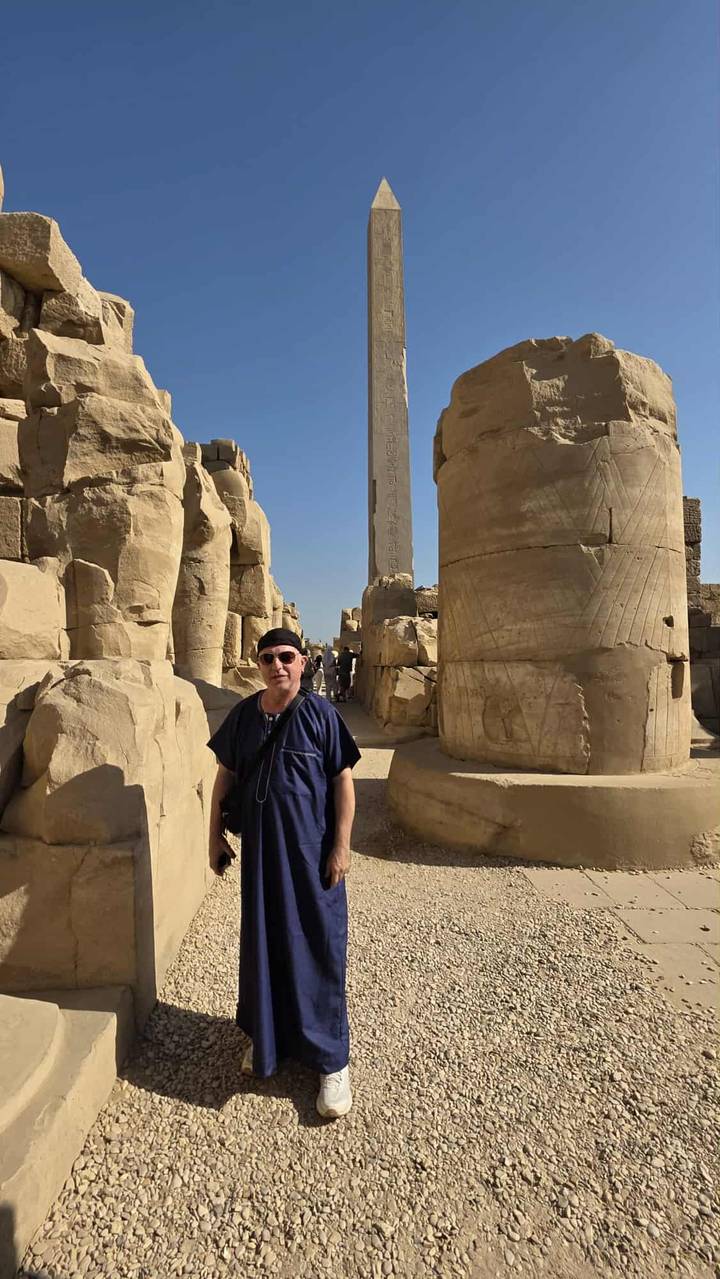 Person posing in front of ancient columns