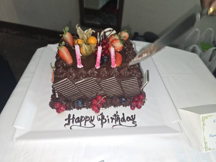 Gâteau d'anniversaire étant coupé avec un couteau.