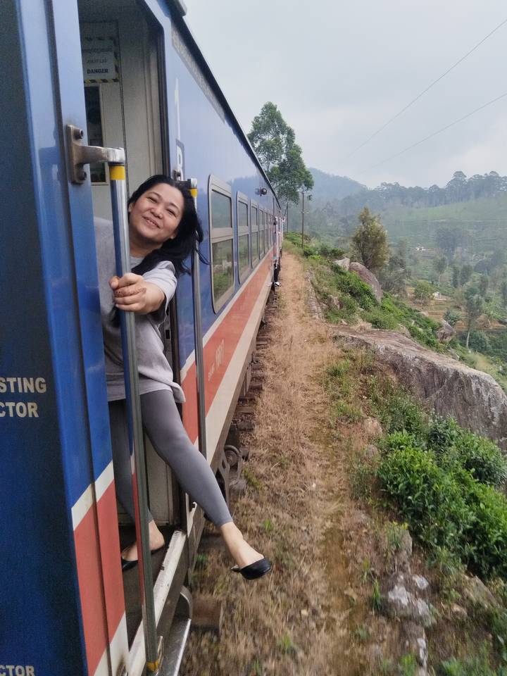 Una mujer asomándose desde un tren en movimiento.