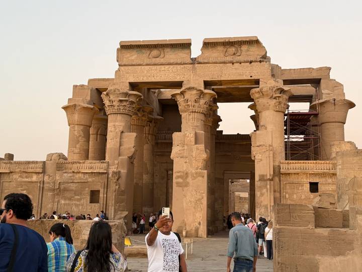 Gran templo egipcio con turistas tomando fotos.