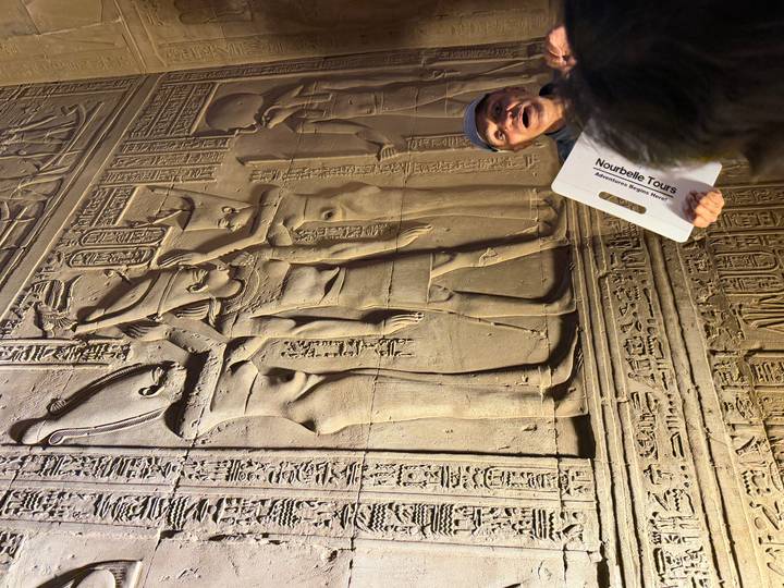 Guía turístico explicando jeroglíficos en una pared del antiguo Egipto.