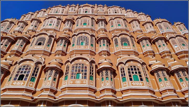Hawa Mahal mit seiner detaillierten Architektur vor einem blauen Himmel.