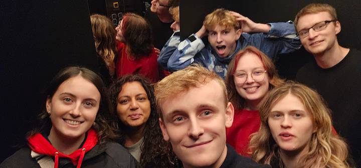 Gruppe junger Leute in einem Aufzug, die ein Selfie machen.