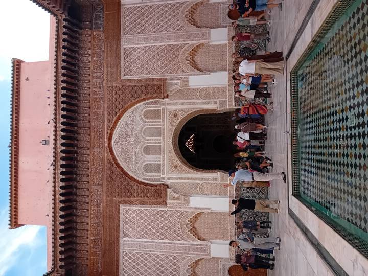 Touristen vor einem wunderschön verzierten marokkanischen Gebäude.