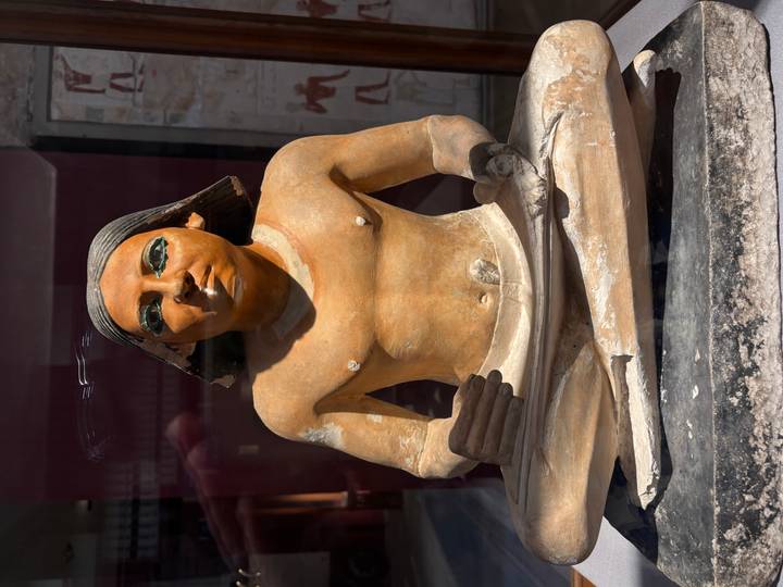 Ägyptische Statue eines sitzenden Schreibers mit detaillierten Hieroglyphen und Bemalung.
