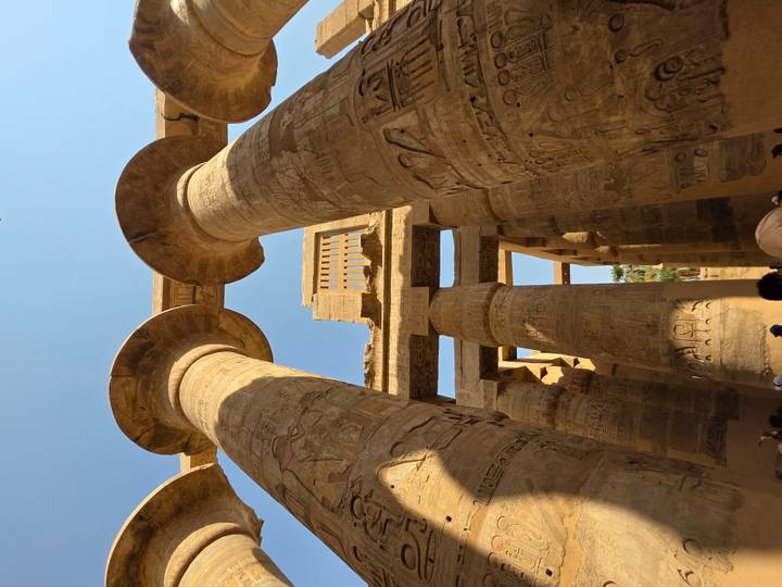 Colonnes égyptiennes antiques avec des touristes à la base.