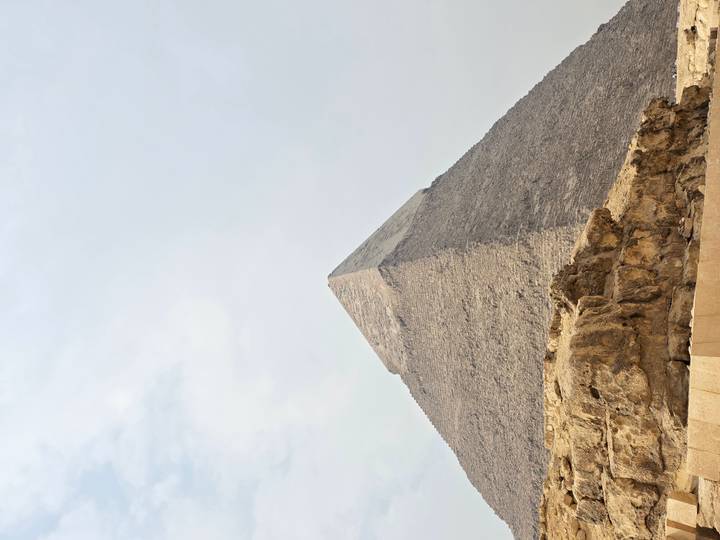 La Grande Pyramide contre un ciel nuageux.