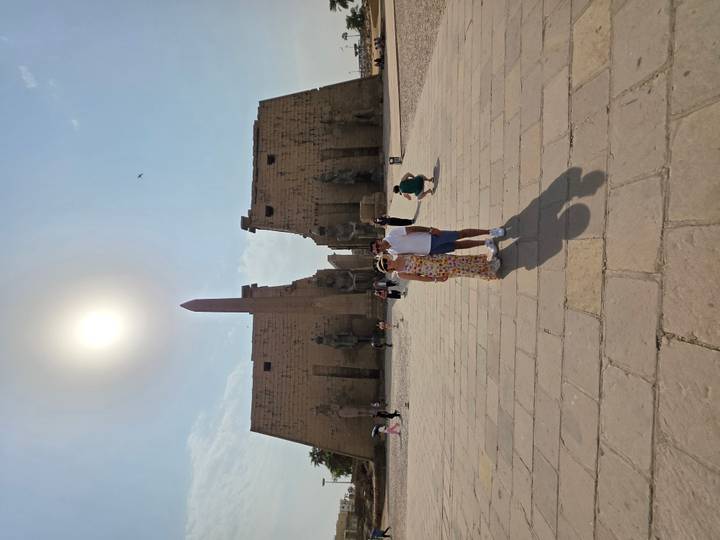Couple posant devant un temple égyptien antique avec un obélisque.