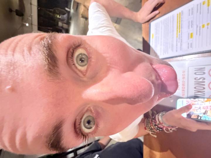 Primer plano de una persona haciendo una mueca junto a un menú