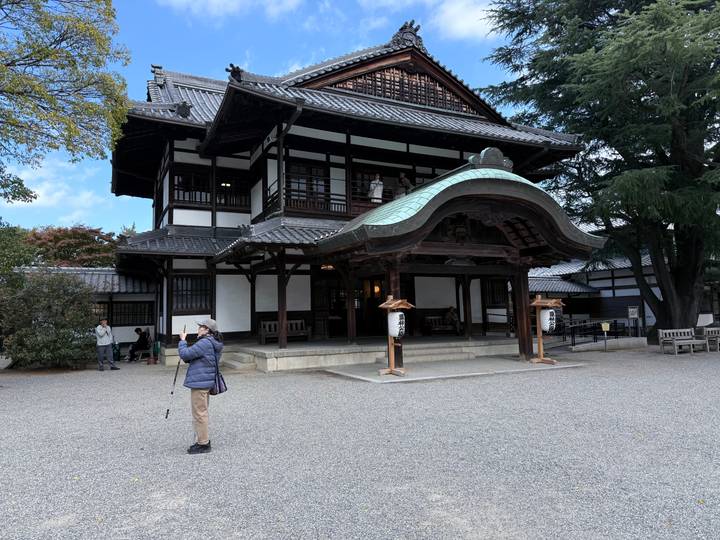 Traditional Japanese building with tourists taking photos.