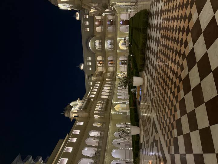 Night view of a grand architectural building with lit arches.