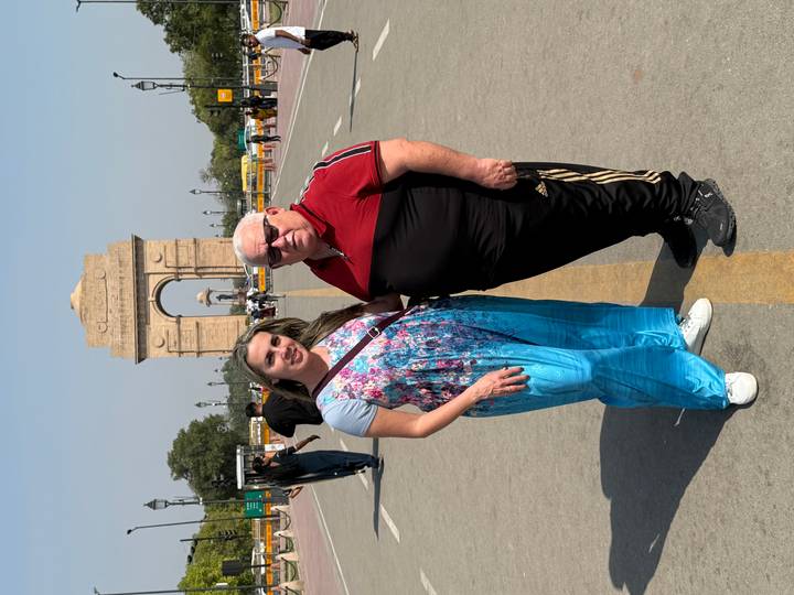 Two people standing in front of the India Gate.