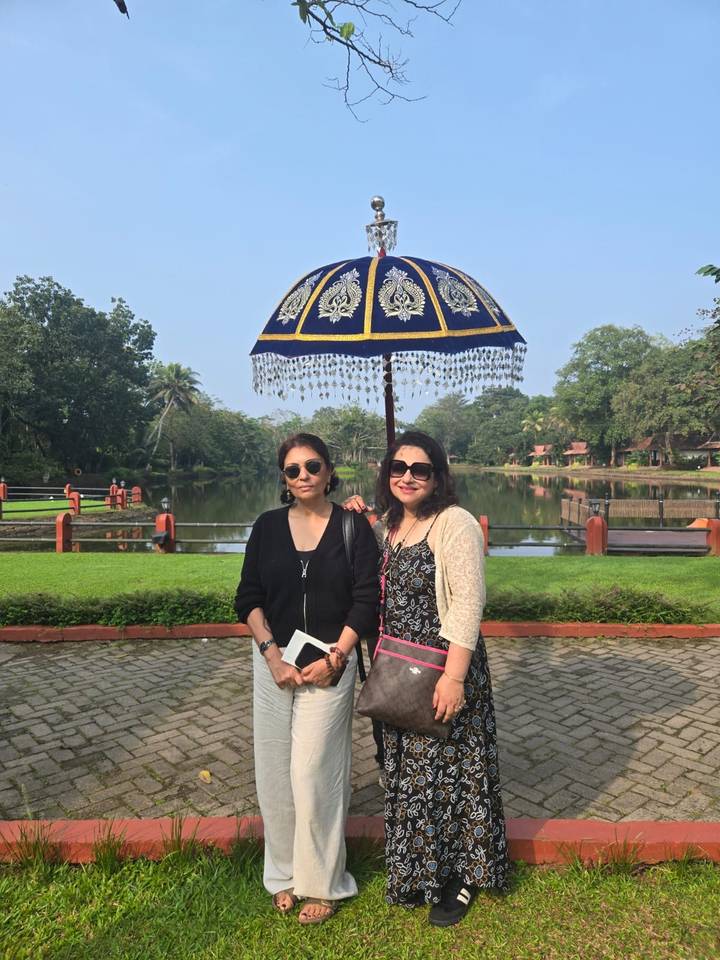 Dos mujeres posando con un paraguas junto a un lago.