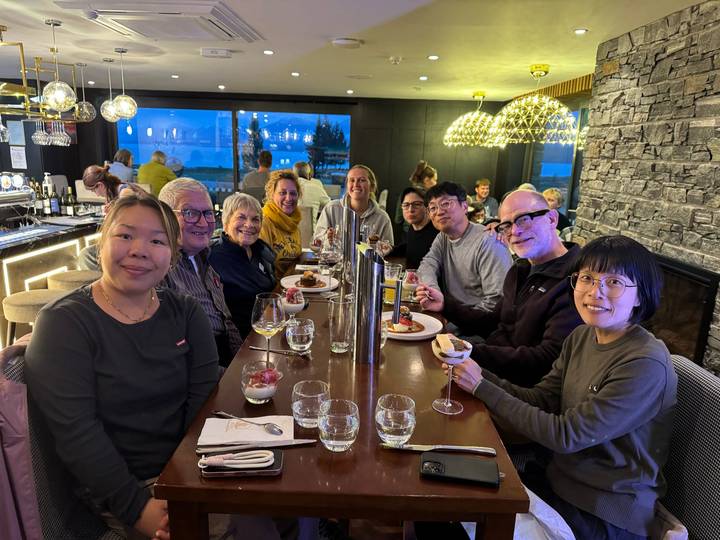 Groep mensen die samen dineren in een restaurant met uitzicht.