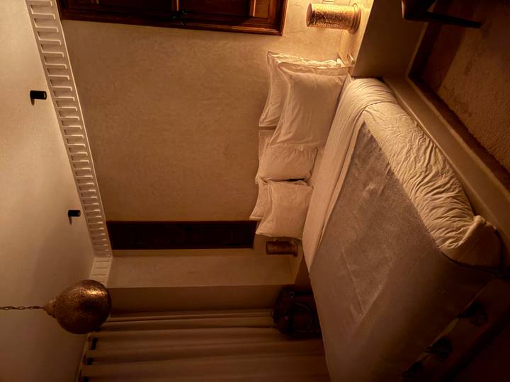 Chambre confortable avec éclairage chaleureux et décoration traditionnelle.