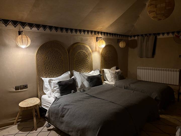 Lits jumeaux dans une chambre chaleureusement éclairée avec une décoration traditionnelle.