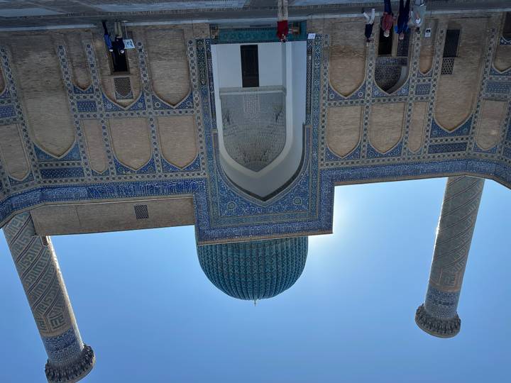 Una mezquita with baldosas azules llamativas y torres bajo un cielo azul.