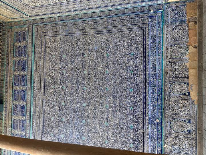 Trabajo de azulejos intrincado con patrones, posiblemente en la pared de un edificio histórico.