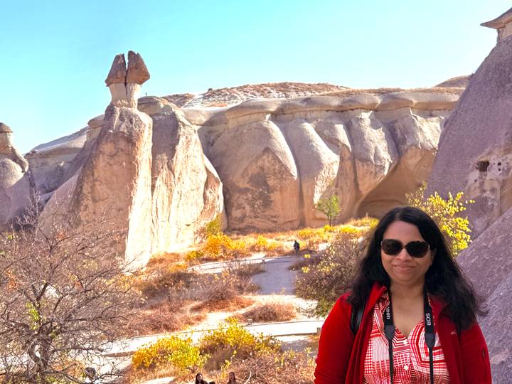 Eine Frau posiert vor einzigartigen Felsformationen.