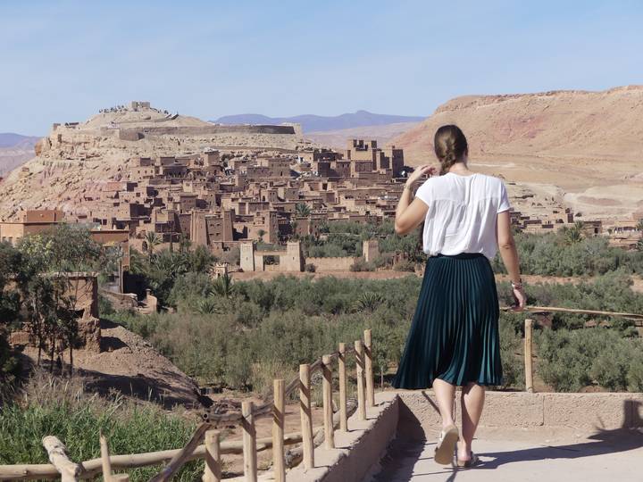 Person overlooking the historic site of a town with rugged terrain.