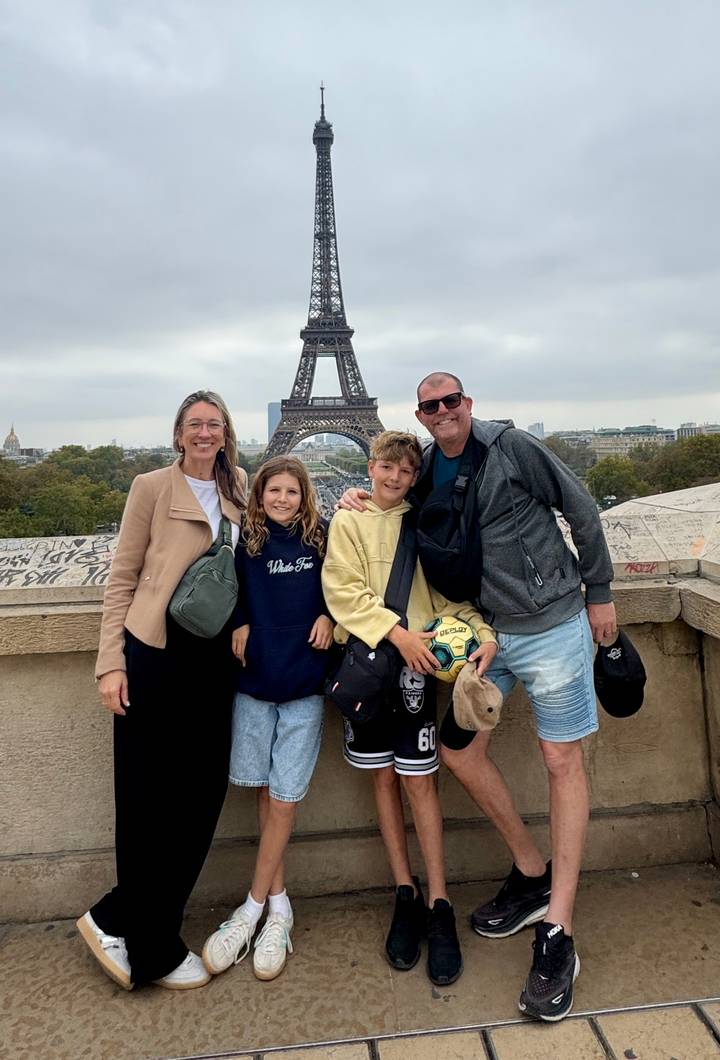 Eine vierköpfige Familie posiert vor dem Eiffelturm.