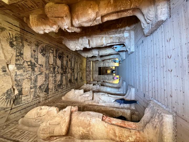 Vista interior de un salón de templo antiguo con estatuas.