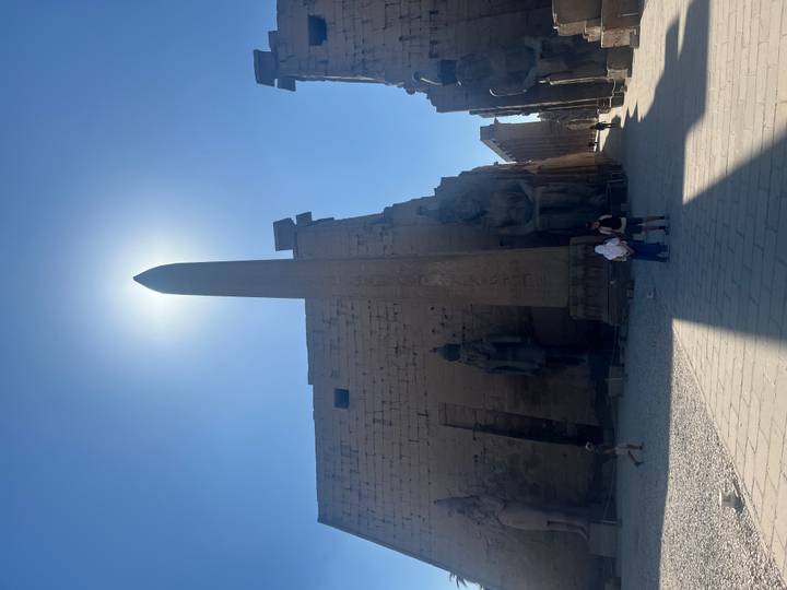 Patio del templo con un obelisco alto en el centro.