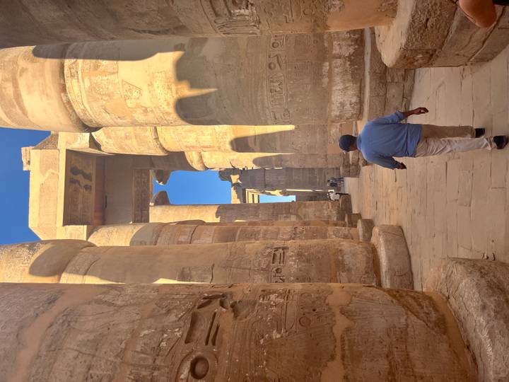 Columnata de un templo antiguo con un visitante.