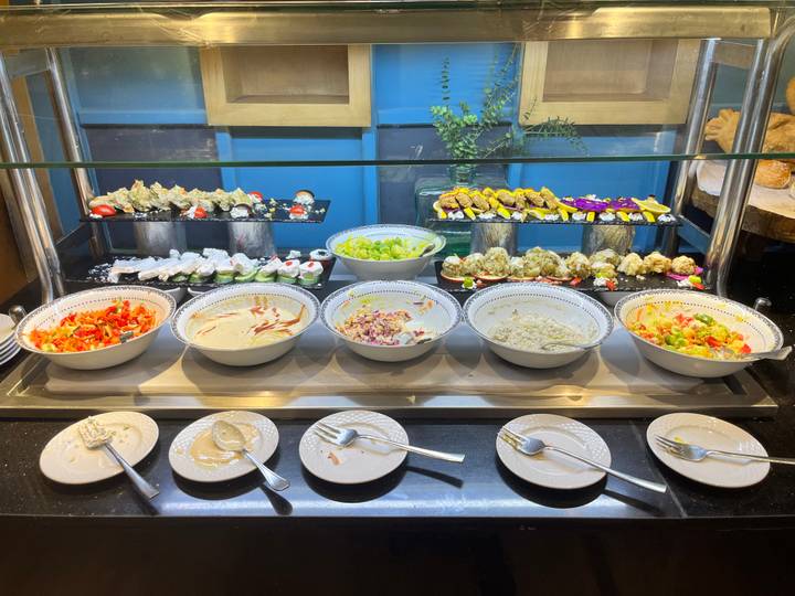 Buffet con varios platos y ensaladas.