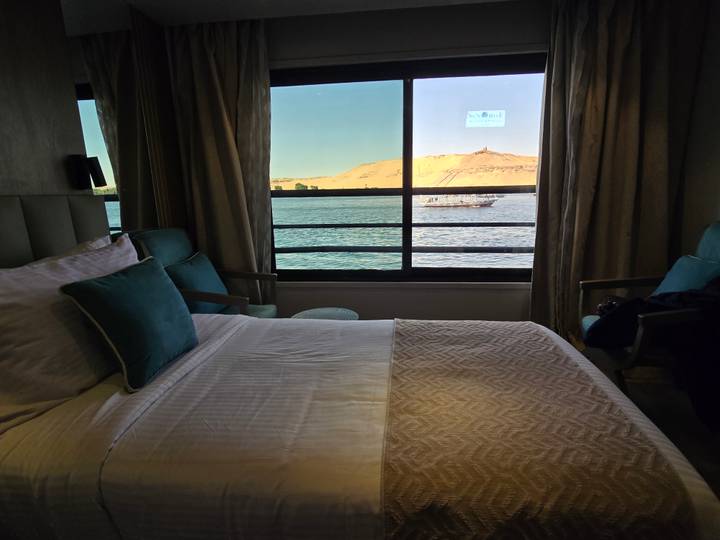Vista del río desde la ventana de un dormitorio con un barco.