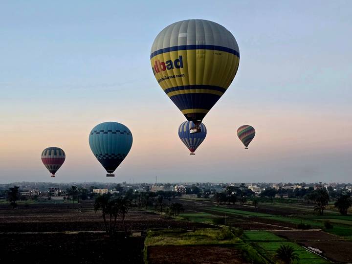 Globos aerostáticos al atardecer flotando sobre los campos.
