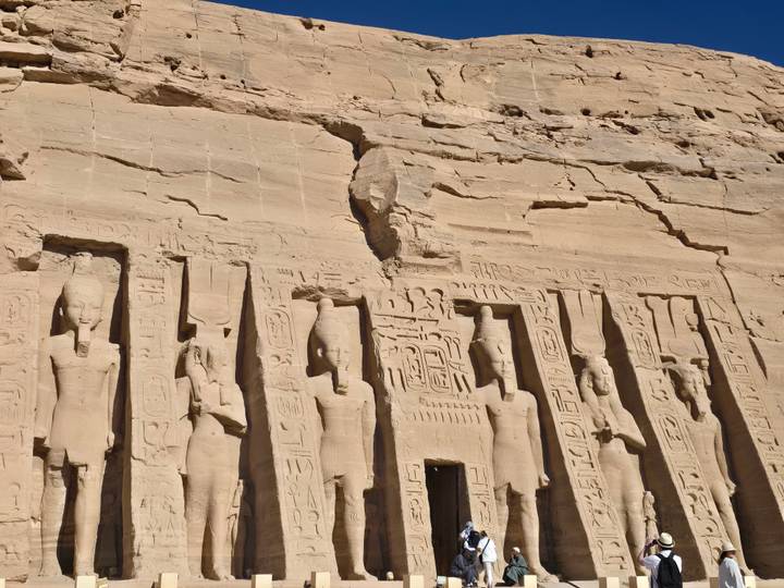 Estatuas talladas en la fachada de un antiguo templo excavado en roca.