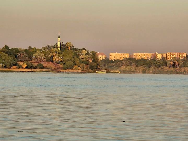 Vista pacífica del río con una mezquita al fondo.
