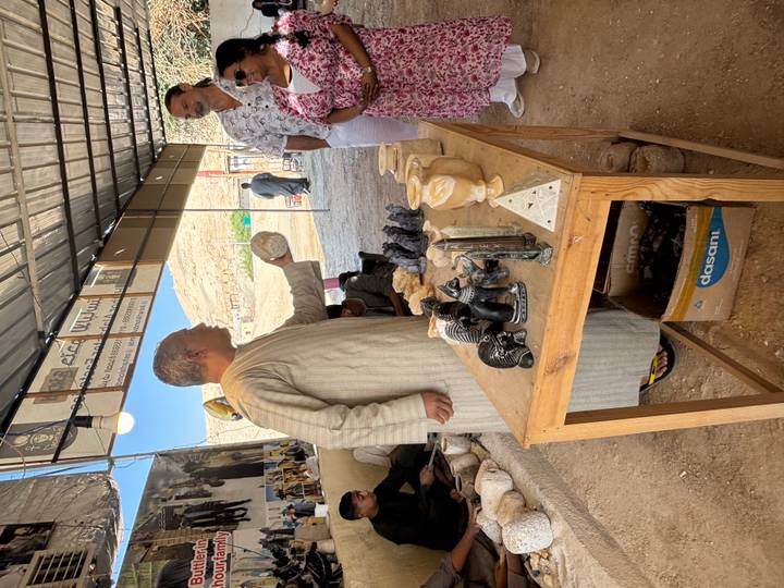 Man die steensnijwerk verkoopt aan een marktkraam.