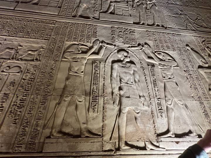 Gedetailleerde steenbewerking op een oude Egyptische tempelmuur.