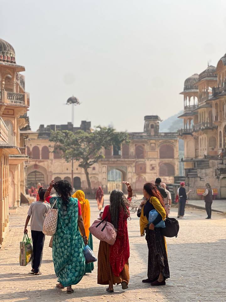 Mujeres caminando en un patio de un edificio histórico indio