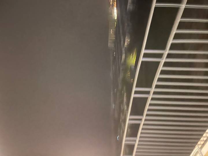 Vista nocturna borrosa desde el balcón de un edificio.