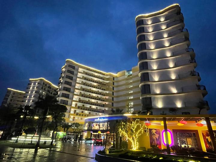 Sección de un hotel con iluminación decorativa y árboles.