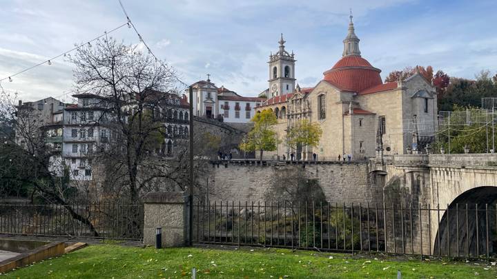 Iglesia histórica y edificios circundantes con un puente de piedra.