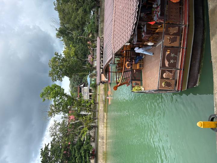 Boote, die entlang eines Flusses mit grüner Umgebung angelegt haben.