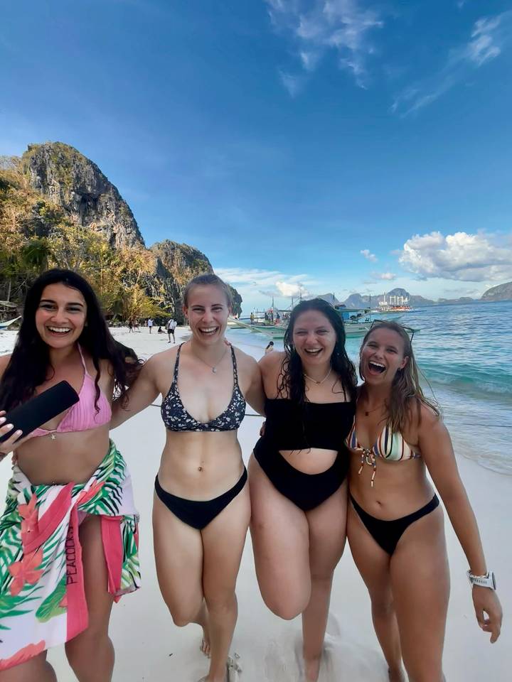 Vier Frauen posieren an einem tropischen Strand