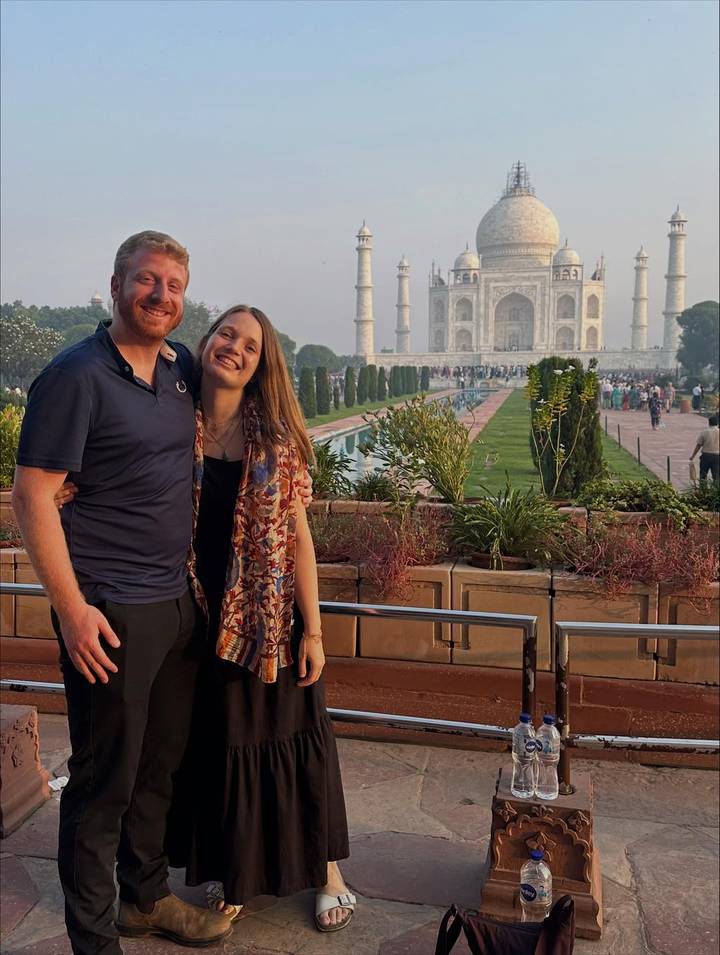 Couple posing in front of the Taj Mahal.