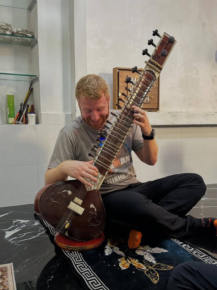 Person playing a sitar with joy.