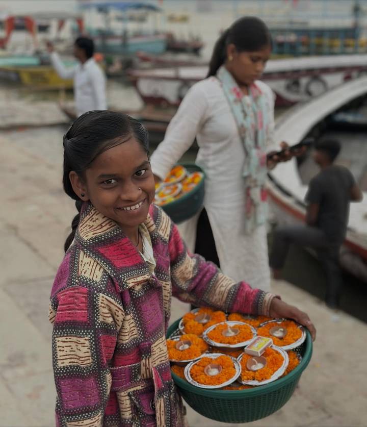 Smiling girl at a riverside market.