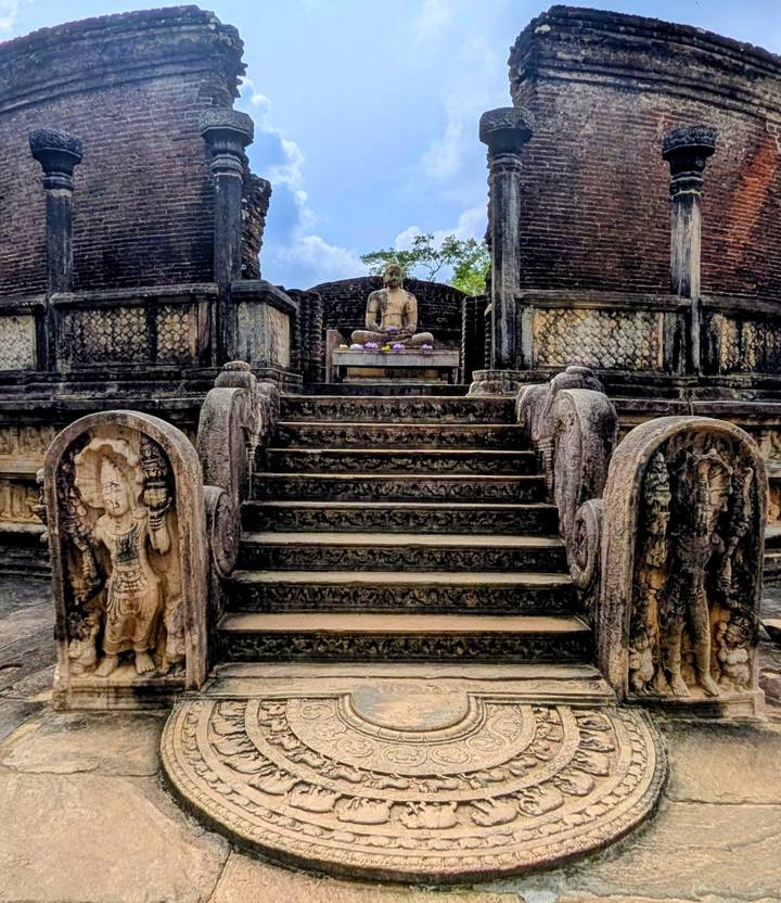 Estatua de Buda y tallados ornamentados en una estructura de piedra antigua.
