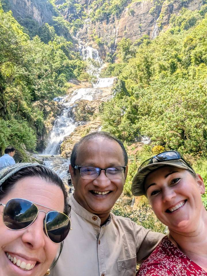 Personas sonrientes con una cascada de fondo.