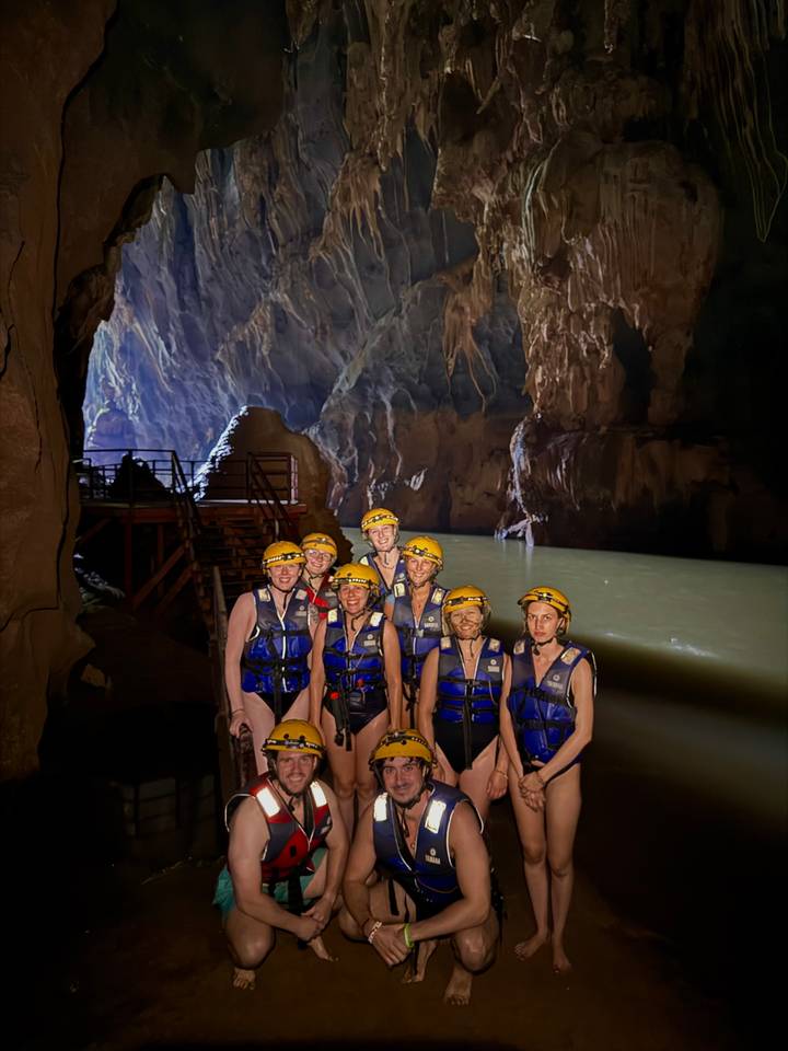 Een groep mensen die helmen en vesten dragen in een grot.