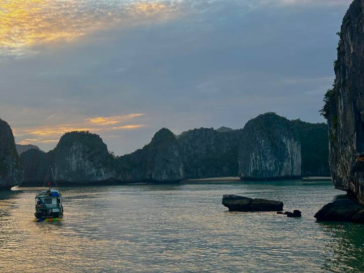 Een boot die vaart in een prachtige baai met kalkstenen eilanden.