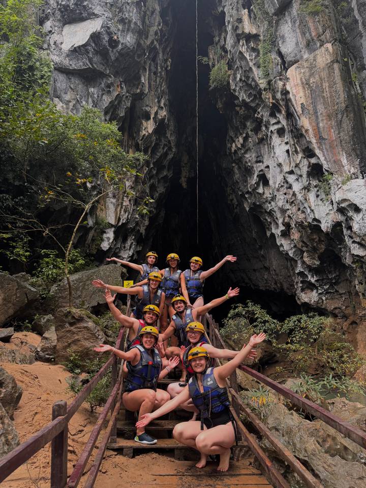 Groep mensen voor een grotingang.